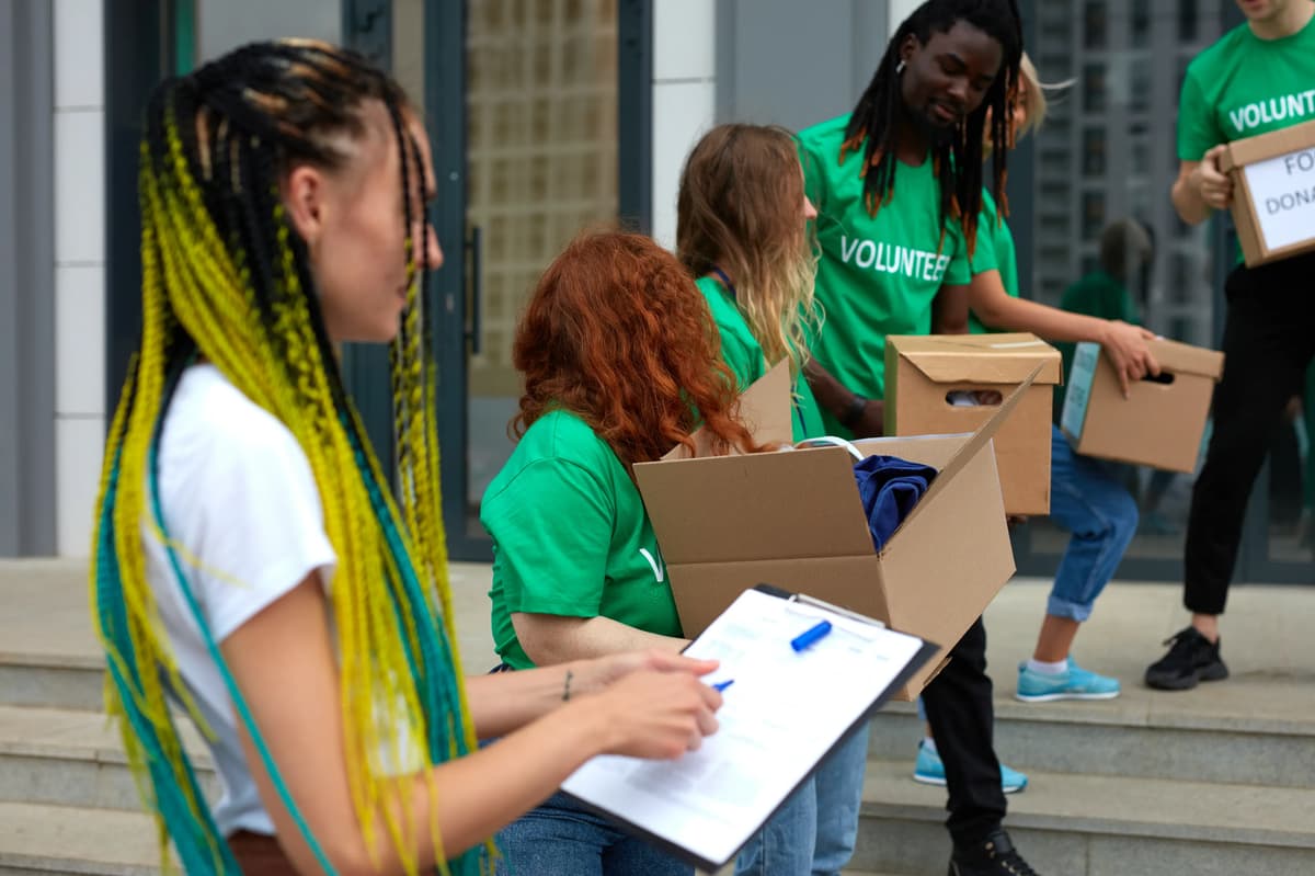 a group of people standing outside with boxes and a clipboard